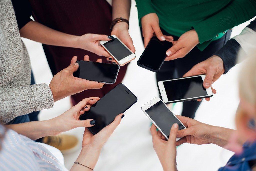 Group of people holding smartphones in a huddle