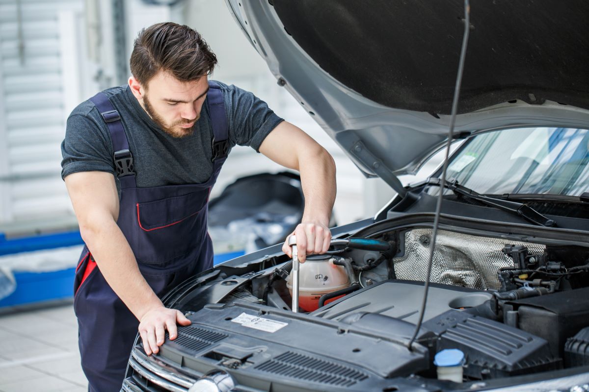 mechanic working on the engine bay of a car