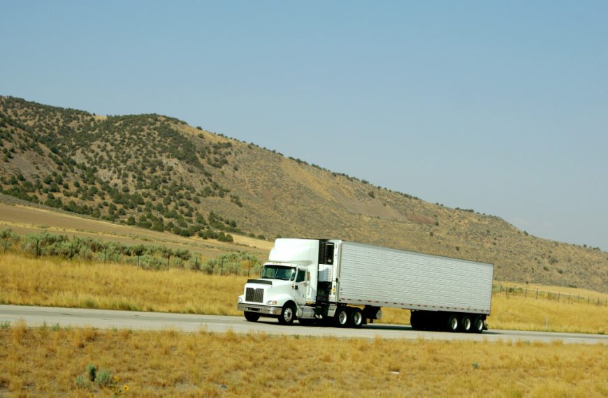 Semi truck driving along an interstate highway.
